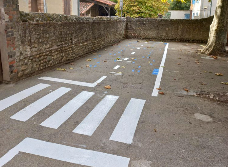 r&eacute;alisation d'un marquage pi&eacute;tonnier dans la cour de l'&eacute;cole et d'une route avec les petits pas dessin&eacute;s