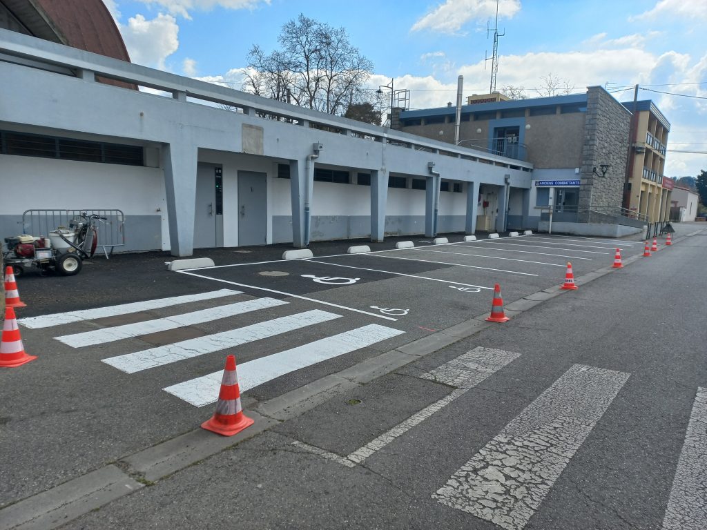 r&eacute;alisation d'un marquage avec places de stationnement + PMR et bande de passage avec logo bonhomme