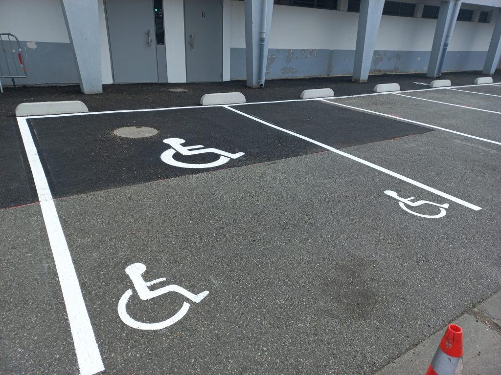 r&eacute;alisation d'une place handicap&eacute;e PMR avec le logo principal centr&eacute; et 2 autres logos PMR de chaque cot&eacute; suivant les normes en vigueur